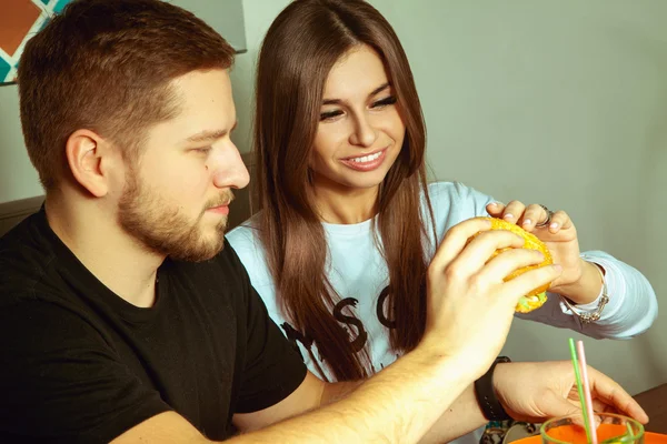 Eszik hamburgert egy nővel fickót — Stock Fotó