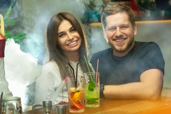 Gelukkige paar aan de bar glimlachend op camera — Stockfoto