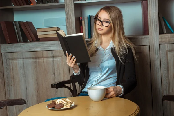 Dziewczyna w okularach czytaj herbaty — Zdjęcie stockowe
