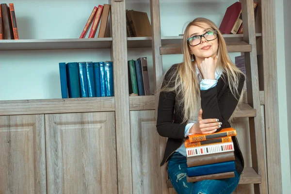 Interessante meisje met een verscheidenheid van boeken in de bibliotheek — Stockfoto