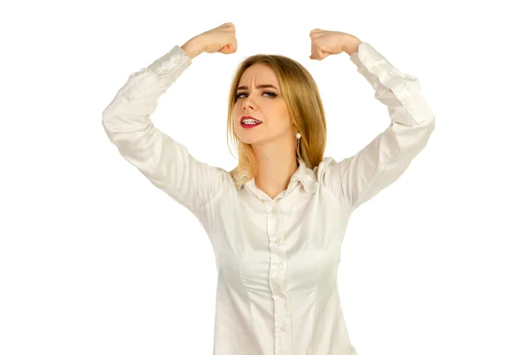Серьезная молодая девушка показывает мышцы в белой рубашке — стоковое фото