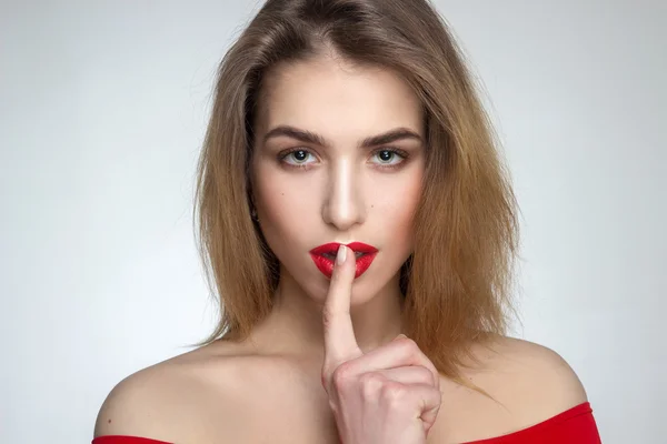 Mujer con los labios rojos y el dedo en la boca — Foto de Stock