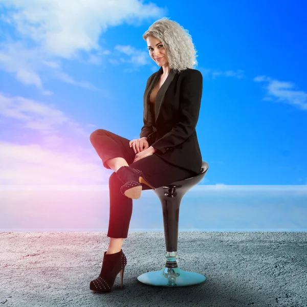 Uroczą kobietą biznesu, pozowanie na krzesło — Zdjęcie stockowe