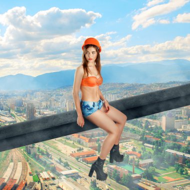 woman builder sits on a crossbar