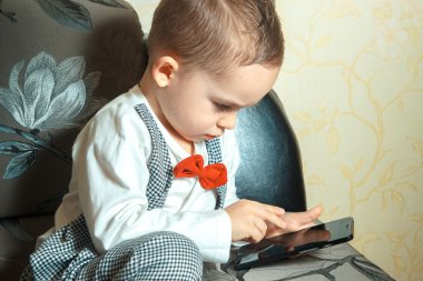 Cep telefonu olan küçük çocuk.