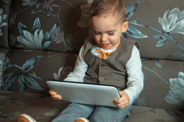 tablet ile takım elbiseli küçük çocuk