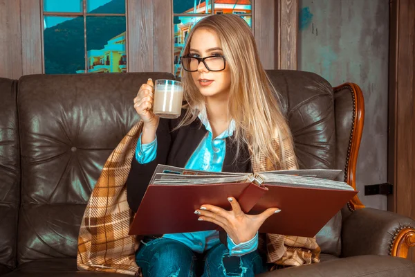 Chica con un libro en el sofá — Foto de Stock