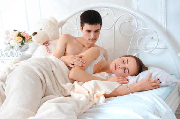 Lovers lying on white bed — Stock Photo, Image