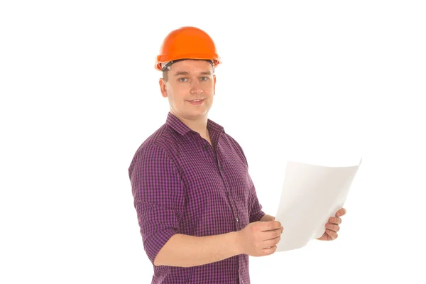 Веселый строитель в шлеме с планом в руках — стоковое фото