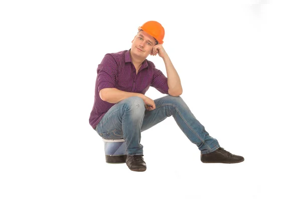 Человек строительный червь сидит на ведре — стоковое фото