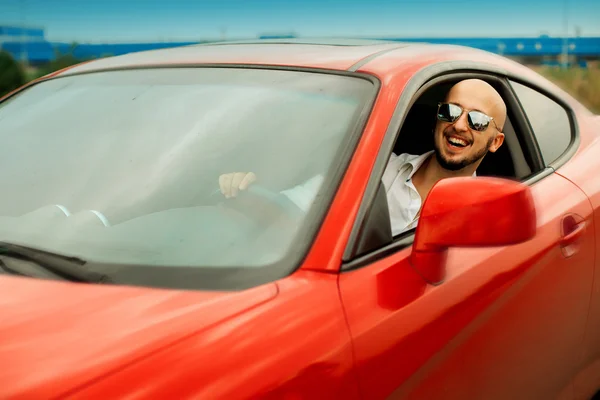 Homem feliz sriving um carro esporte vermelho — Fotografia de Stock