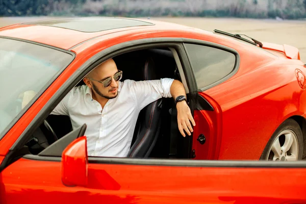 Красивый мужчина в солнцезащитных очках в спортивном автомобиле — стоковое фото