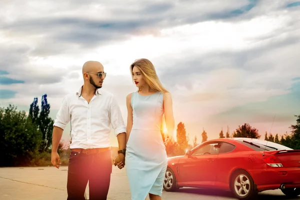 Couple in love go away from a sport car — Stock Photo, Image