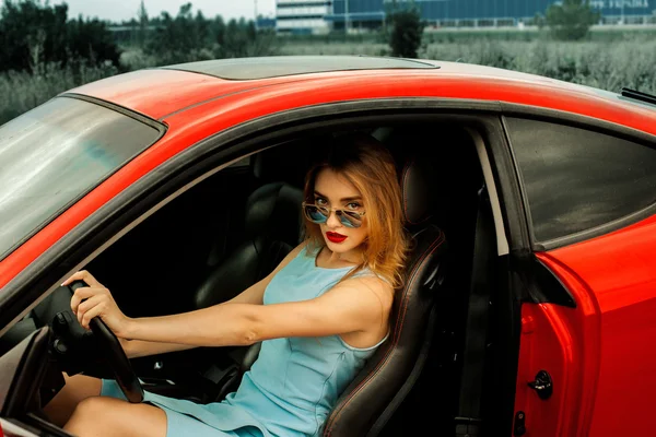 Krásná mladá dáma v červené auto — Stock fotografie
