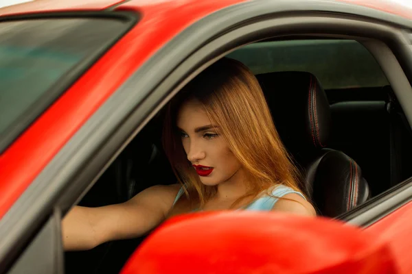 Frau mit roten Lippen am Steuer eines Autos — Stockfoto