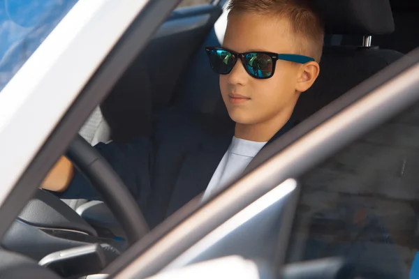 Boy in glasses driving a car — Stock Photo, Image