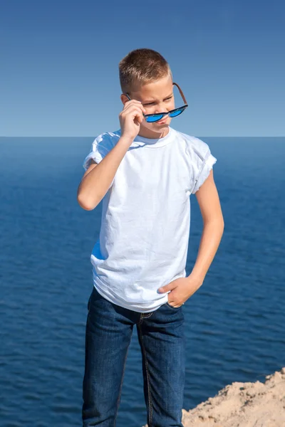 Модный мальчик в солнечных очках на пляже — стоковое фото