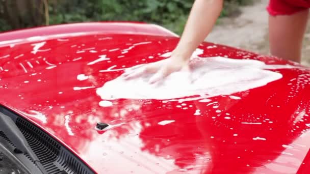 Mujer lava coche rojo — Vídeo de stock