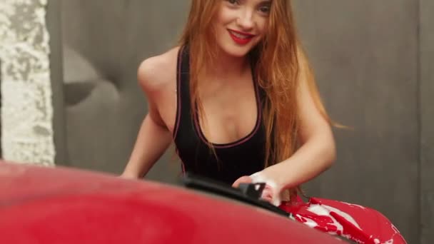 Mujer joven con labios rojos lava un coche — Vídeos de Stock