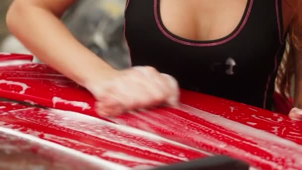 Young girl washes a red sport car — Stock Video