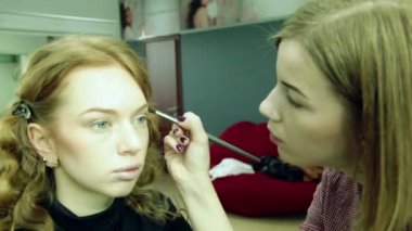 kadın bir makyaj güzel bir kızla koyar.