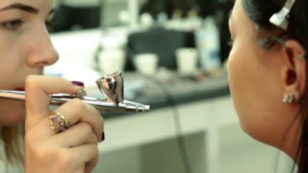 Женщина накладывает макияж красивой девушке — стоковое видео