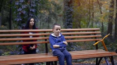 Güzel esmer anne, sıcak bir sonbahar gününde küçük oğluna arkadan sokuluyor.