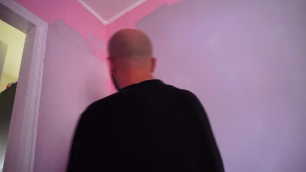 Man målar väggarna i rummet med en färg roller — Stockvideo