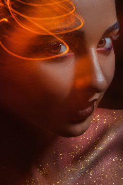 Kameraya bakarak yaratıcı turuncu ışık beyaz kadınla