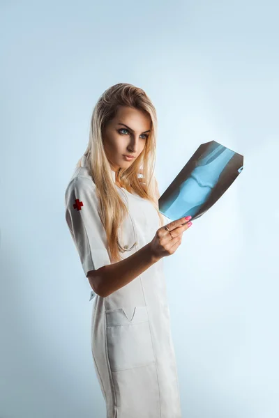 Blonde adult nurse checks x-ray photo — Stock Photo, Image