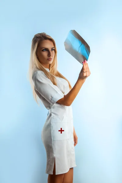 Fashion model nurse looking at radiograph — Stock Photo, Image