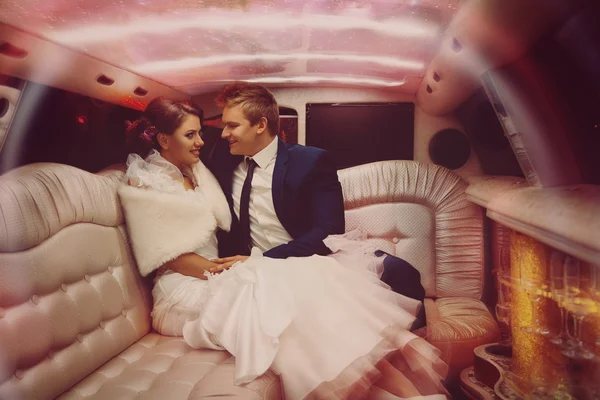 Horizontales Porträt der schönen Braut und Verlobten machen sich in der Limousine lustig — Stockfoto