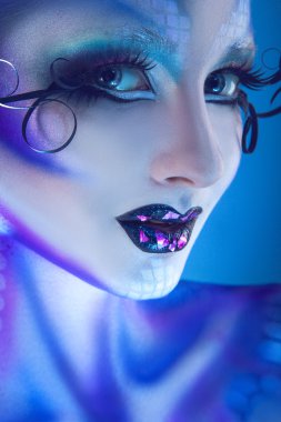 Kameraya bakarak yaratıcı yüz sanatı ile güzel mutlu kadın ve