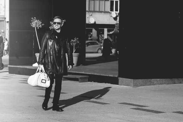 Foto en blanco y negro del hermoso modelo masculino en gafas de sol caminando —  Fotos de Stock
