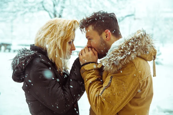 Guy kisses the hand of a lady in the snow — Stock Photo, Image