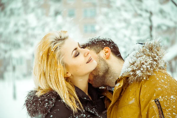 Passionate guy kisses girl with white hair in neck on street in — Stock Photo, Image