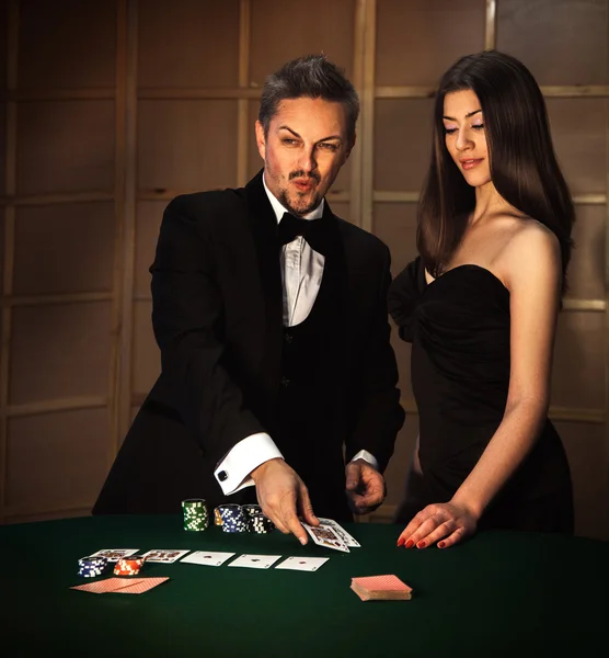 Fyrkantiga foto av sexuella par i elegant kostym att spela poker — Stockfoto