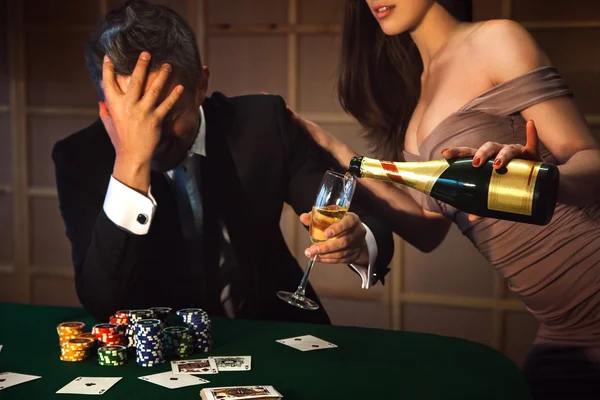 Dramatic photo loser poker man and lady pours him a glass of cha — Stock Photo, Image