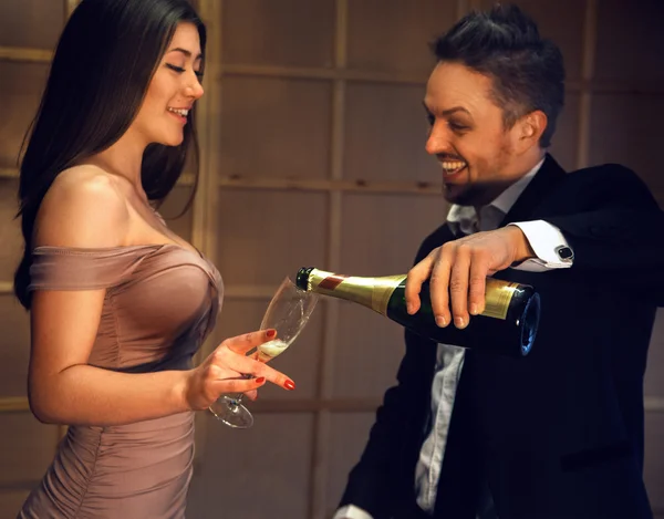 Celebrating a happy laughing couple with a glass of champagne — Stock Photo, Image