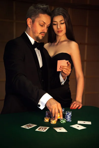 Nice man in elegant suit looking cards with his sexual woman and — Stock Photo, Image