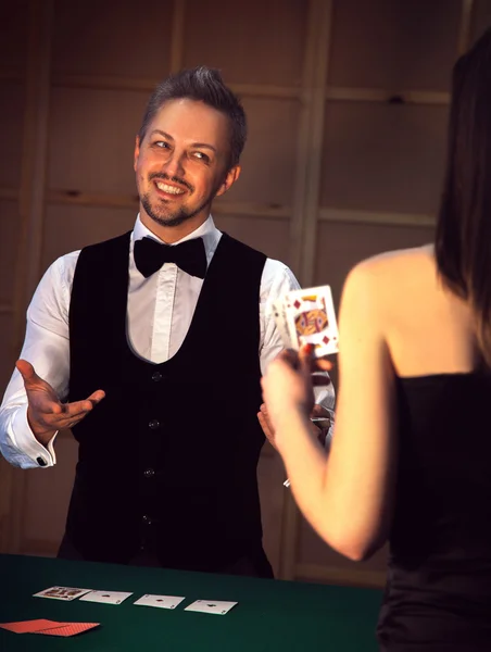 Elegant dealer smiling girls playing poker — Stock Photo, Image