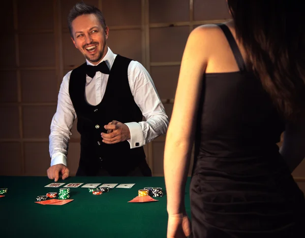 Dealer deals the cards in a casino and laughs — Stock Photo, Image