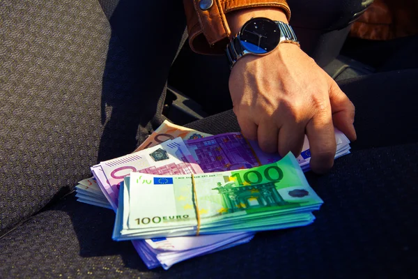 Male hand taking a lot of money from passenger sit — Stock Photo, Image