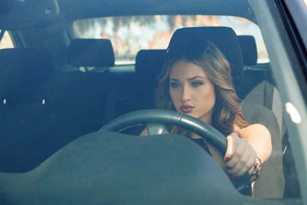 Schöne junge erwachsene Mädchen konzentriert sich auf das Autofahren — Stockfoto