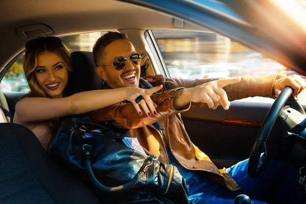Disfrutar de la vida divertida pareja conduciendo coche a alta velocidad y dedo índice — Foto de Stock