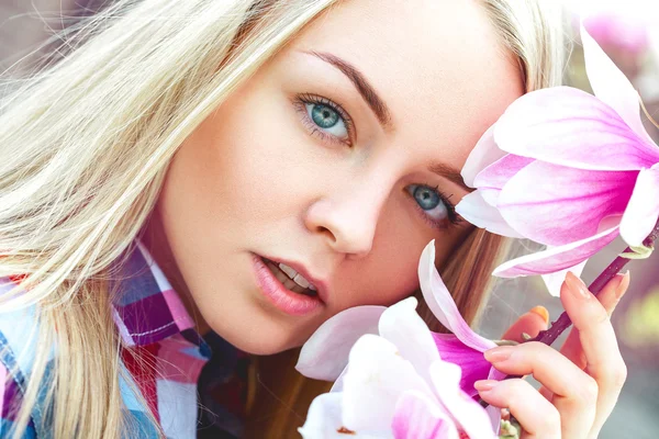 Porträt einer hübschen jungen blonden Frau mit rosa Blumen — Stockfoto