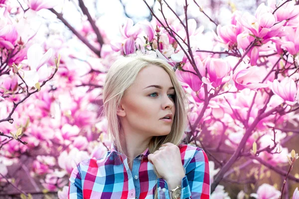 Horizontale jonge sexy blonde vrouw op zoek weg met roze bloem — Stockfoto