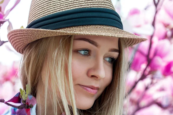 Młoda kobieta blondynka cutie kapelusz patrząc od hotelu z kwiatami — Zdjęcie stockowe