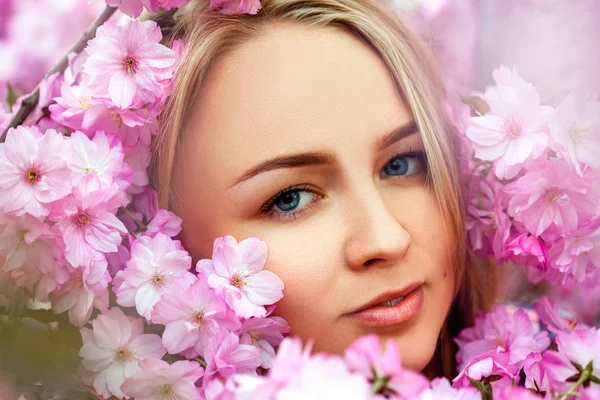 Modeporträt der sexuellen Schönheit Blondine in blühender rosa Blume — Stockfoto