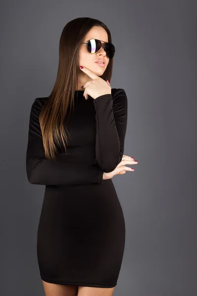 Morena adulta en vestido negro y gafas de sol mirando hacia otro lado en stu — Foto de Stock